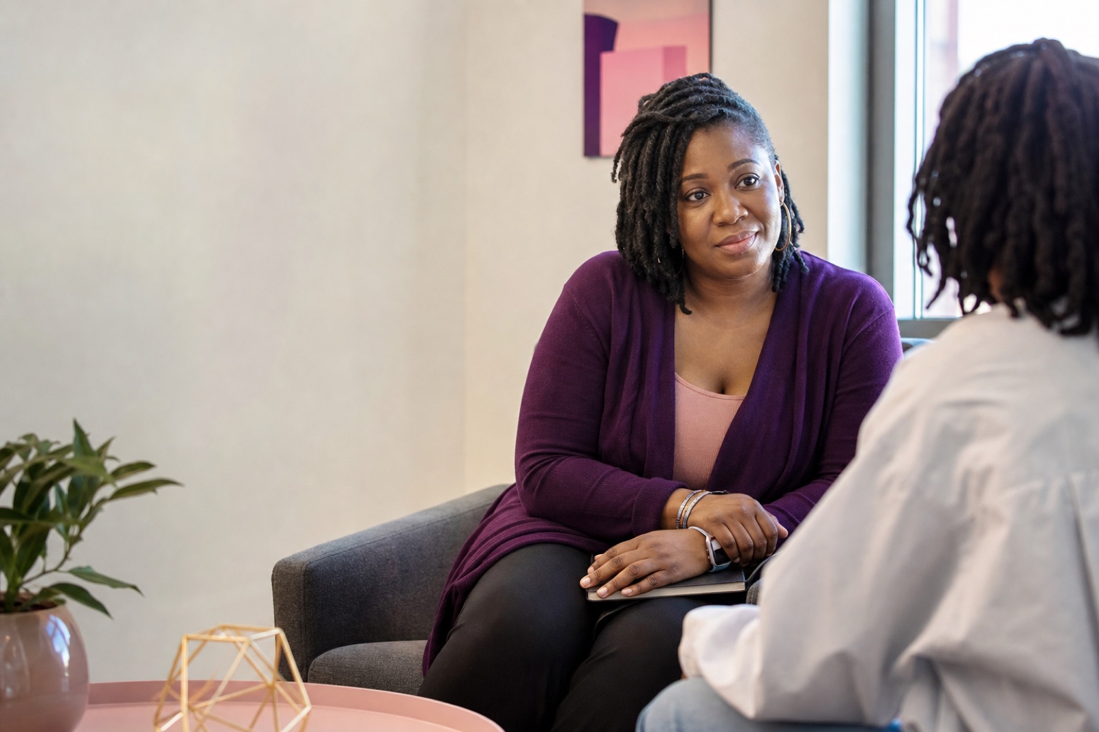 A care coordinator listening to a client in a welcoming community office