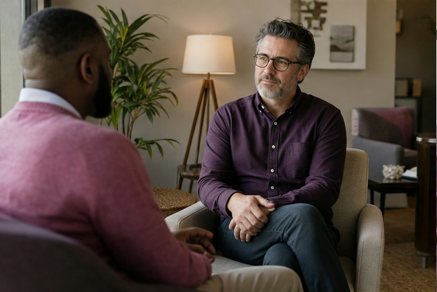 A clinician and client talking in a calm outpatient mental health office
