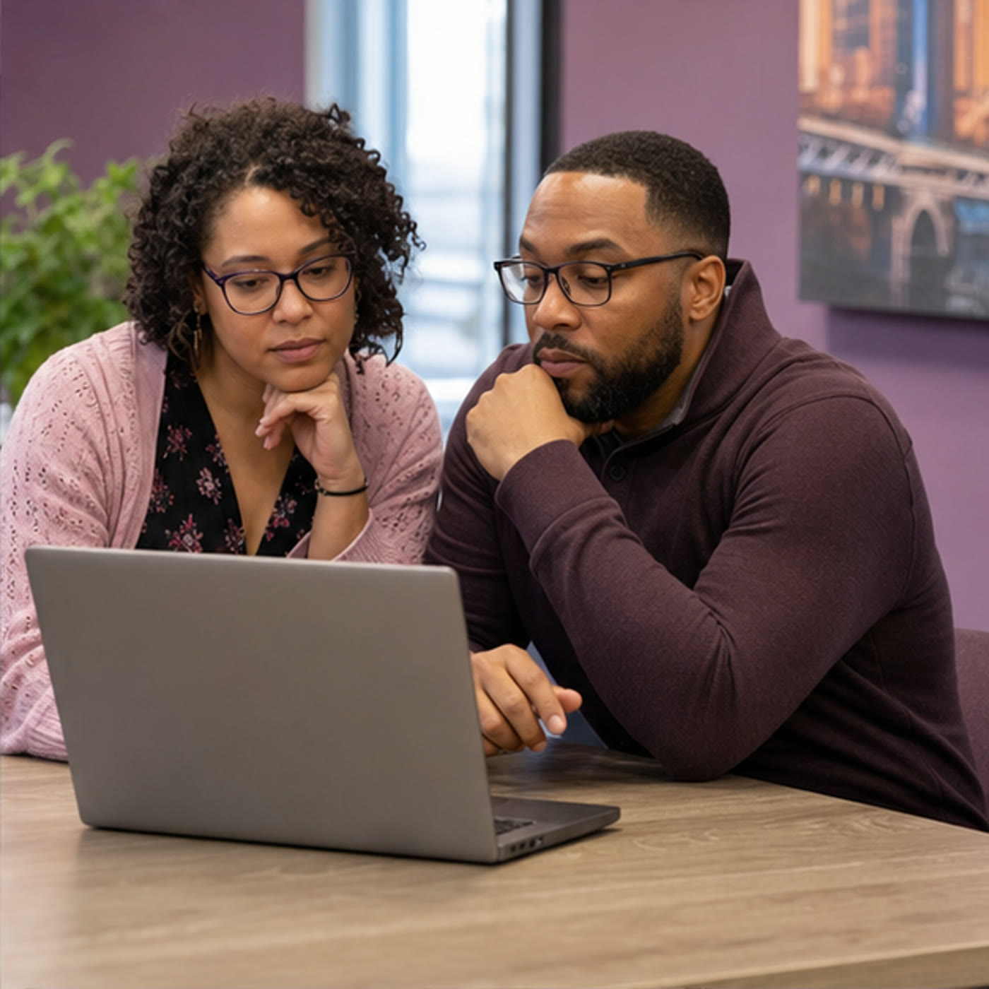 Two staff members reviewing website terms on a laptop